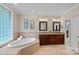 Elegant bathroom with a soaking tub, double vanity, and tile flooring, offering a blend of comfort and style at 166 Pinnacle Shores Dr, Mooresville, NC 28117