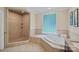 Luxurious bathroom with a walk-in shower, soaking tub, and neutral tiling, providing a spa-like experience at 166 Pinnacle Shores Dr, Mooresville, NC 28117