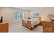 Cozy bedroom with carpet, neutral walls, a comfortable bed, and a view of the yard through a bright window at 166 Pinnacle Shores Dr, Mooresville, NC 28117