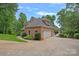 Angle shot of a brick house with a three car garage and lush yard at 166 Pinnacle Shores Dr, Mooresville, NC 28117