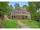 Stately brick home with multiple levels, a large lawn, and covered balconies perfect for outdoor living at 166 Pinnacle Shores Dr, Mooresville, NC 28117