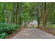 Long driveway leads to a brick house surrounded by mature trees and blue hydrangeas at 166 Pinnacle Shores Dr, Mooresville, NC 28117