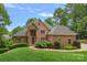 Charming red brick home featuring a manicured front yard and a vibrant red front door at 166 Pinnacle Shores Dr, Mooresville, NC 28117