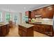Well-lit kitchen featuring custom cabinetry, a center island, granite countertops, and stainless appliances at 166 Pinnacle Shores Dr, Mooresville, NC 28117