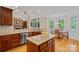 Gourmet kitchen featuring granite countertops, island seating, and seamlessly connects to the dining area at 166 Pinnacle Shores Dr, Mooresville, NC 28117