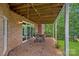 Covered patio with brick flooring, featuring an outdoor dining set perfect for entertaining with a view of the greenery at 166 Pinnacle Shores Dr, Mooresville, NC 28117