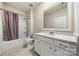 Bathroom featuring a bathtub-shower combo, vanity with modern fixtures, and neutral tiling at 17028 River Race Dr, Huntersville, NC 28078