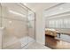 Modern bathroom showcasing glass shower, tiled walls, and a view into the main bedroom at 17028 River Race Dr, Huntersville, NC 28078