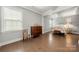 Well-lit bedroom featuring a stylish accent wall, hardwood floors, and ample natural light at 17028 River Race Dr, Huntersville, NC 28078