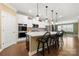 Modern kitchen with white cabinetry, pendant lighting, island seating, and stainless steel appliances at 17028 River Race Dr, Huntersville, NC 28078