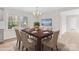 Dining room features a wood table with seating for six, a modern chandelier, and a large window for natural light at 174 Maske Rd, Mount Gilead, NC 27306