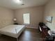 Bedroom with wood-look flooring, a window, and a desk area at 190 Watering Trough Rd, Statesville, NC 28677