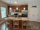 Open kitchen with granite countertops, stainless appliances, island seating, and a bright pantry at 190 Watering Trough Rd, Statesville, NC 28677