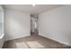 Neutral bedroom with gray floors has an ensuite door and sunny window showcasing a clean, minimalist space at 1941 32Nd Ne St, Hickory, NC 28601