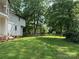 Large backyard with a storage building in the back, green lawn and large trees at 204 N Gaston St, Kings Mountain, NC 28086