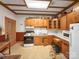 Vintage kitchen with wood cabinets, white appliances, patterned floor, and eat-in area at 204 N Gaston St, Kings Mountain, NC 28086
