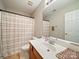 A bright bathroom features a shower with patterned curtain, a white sink and vanity at 2111 Elendil Ln, Charlotte, NC 28269
