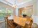 Bright dining room showcases a rustic table, chandelier lighting and a sun-filled window at 2111 Elendil Ln, Charlotte, NC 28269