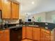 Modern kitchen area with wood cabinets, sleek black appliances, and granite countertops at 2111 Elendil Ln, Charlotte, NC 28269
