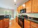 Kitchen area boasting sleek black countertops, stainless appliances, and rich wood cabinets at 2111 Elendil Ln, Charlotte, NC 28269