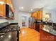 View of kitchen with black appliances, wood cabinets, and hardwood flooring at 2111 Elendil Ln, Charlotte, NC 28269