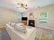 Cozy living room featuring a fireplace, a comfortable sofa, and large windows, creating a warm and inviting space at 2111 Elendil Ln, Charlotte, NC 28269
