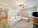 Comfortable living room with a white sectional sofa, an area rug, and a view of the front door, perfect for relaxation at 2111 Elendil Ln, Charlotte, NC 28269