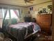 A bedroom with a large window for plenty of sunlight and a wooden dresser at 2165 Peanuts Ln, Newton, NC 28658