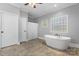 Bright bathroom features a modern free-standing tub, neutral paint, and many windows at 2458 Genelia Dr, Claremont, NC 28610