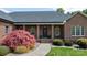 Charming brick home with a manicured front yard and covered front porch showcasing a red Japanese maple at 2458 Genelia Dr, Claremont, NC 28610