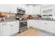 Well-lit kitchen features stainless steel appliances, granite countertops, and white cabinets at 2458 Genelia Dr, Claremont, NC 28610