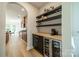 Convenient bar area with stylish wine fridge, countertop, and shelving for glassware and spirits at 2714 Woodlands Creek Dr, Monroe, NC 28110