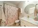 Charming bathroom featuring a vanity, toilet, floral shower curtain, and round decorative mirror at 2714 Woodlands Creek Dr, Monroe, NC 28110