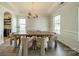 Elegant dining room with tray ceilings, wood floors, modern lighting, and open access to kitchen at 2714 Woodlands Creek Dr, Monroe, NC 28110