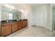 A spacious main bathroom boasting dual sinks, granite countertops, a shower, and tiled floors at 2714 Woodlands Creek Dr, Monroe, NC 28110