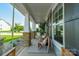 Relaxing front porch featuring stone-clad pillars, comfortable wicker seating, and views of the landscaped yard at 2714 Woodlands Creek Dr, Monroe, NC 28110