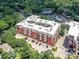Brick apartment building featuring an aerial view that shows community parking spaces and green landscaping at 2810 Selwyn Ave # 104, Charlotte, NC 28209