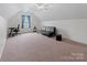Spacious bonus room featuring neutral carpeting, ceiling fan and minimalist furniture at 286 Mallard Head Dr, Rock Hill, SC 29732