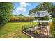 Expansive backyard featuring a well-manicured lawn, a patio set, and a white wooden fence at 314 Sunnywood Ln, Charlotte, NC 28270