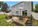 Backyard patio with black metal furniture and a sun umbrella; backyard has a gray house at 314 Sunnywood Ln, Charlotte, NC 28270