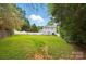 Expansive backyard featuring a well-manicured lawn, a patio set, and a white wooden fence at 314 Sunnywood Ln, Charlotte, NC 28270