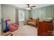 bedroom with green walls, carpet, chair, and a crib by a window at 314 Sunnywood Ln, Charlotte, NC 28270