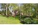 Sprawling backyard featuring lush green grass, colorful gardens, and a beautiful brick home at 3209 Sedgefield Rd, Statesville, NC 28625