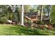 A well-manicured backyard with lush green grass, garden, trees, and a brick home at 3209 Sedgefield Rd, Statesville, NC 28625