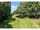 A expansive backyard with well-kept lawn, mature trees, and a view of the sky at 3209 Sedgefield Rd, Statesville, NC 28625