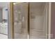 Bathroom featuring a glass enclosed shower stall with a built-in bench and handrails at 3209 Sedgefield Rd, Statesville, NC 28625