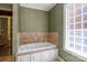 Bright bathroom showcasing a soaking tub with tiled backsplash and a glass block window at 3209 Sedgefield Rd, Statesville, NC 28625