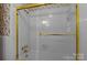 Bathroom featuring a shower and tub combo with gold trim and a patterned wallpaper at 3209 Sedgefield Rd, Statesville, NC 28625
