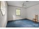 Simple bedroom with blue carpet, two large windows and one chair at 3209 Sedgefield Rd, Statesville, NC 28625