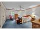 Spacious bedroom with blue carpet, and light walls, featuring a ceiling fan and natural light at 3209 Sedgefield Rd, Statesville, NC 28625